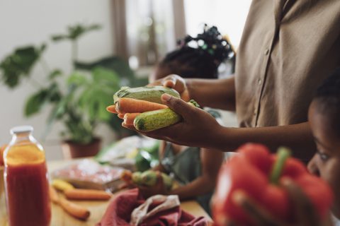 Mother, Daughter And Son Preparing Vegetables For Lunch At A Kitchen Table