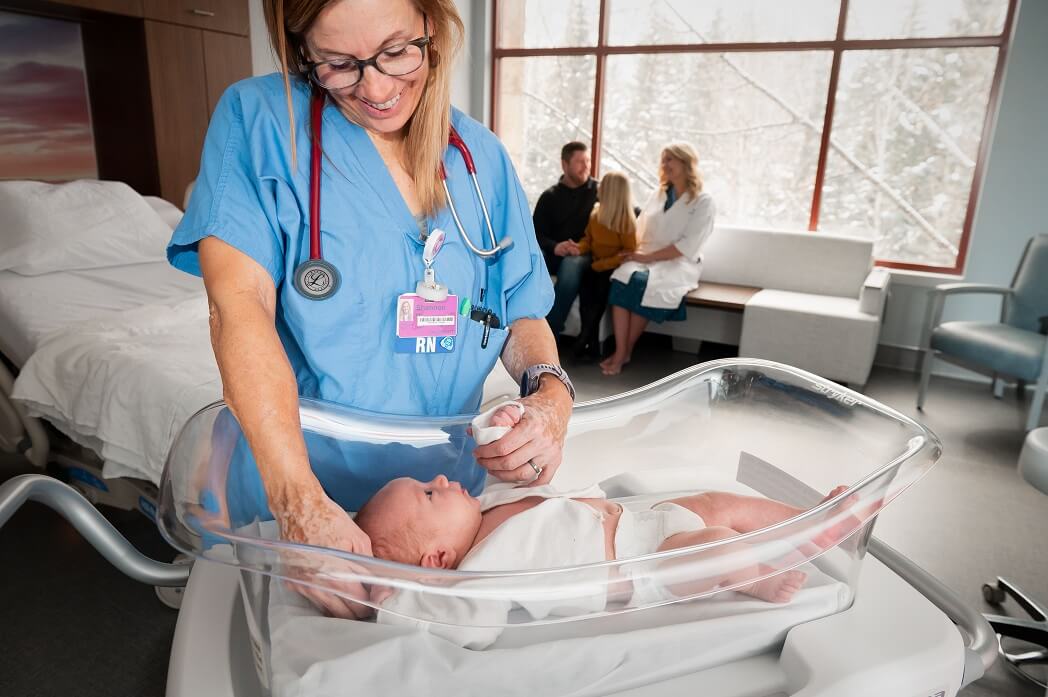 At Vail Health Birth Center, a nurse carefully settles a baby into a crib.