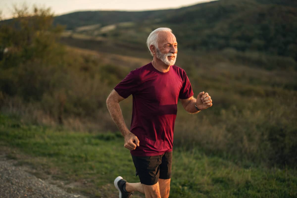 Senior Man Running Outdoors In Nature During A Beautiful Day